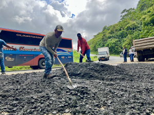 Bacheo emergente con material base en la vía a Puerto Cayo mejorando la circulación vehicular.